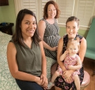 Women and a child sit together in a room. 